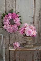Pink Peony wreath on vintage French door, with urn arrangement of cut peony blooms. 