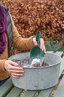 Woman mixing perlite into compost make it lighter. 