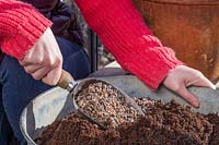 Woman mixing horticultural grit into compost.