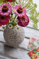 Zinnia, Dill and Daisies in a speckled ceramic vase with Zinnia seed packets. 