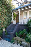 Front steps leading to a verandah of a Victorian-style cottage. 