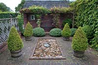 Formal Italian-style paved courtyard with Buxus - box - topiary in containers,
 rectangular pond and Parthenocissus - Virginia creepers climbing over brick 
arbour 