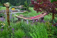 Just Add Water show garden with hammock above perennial planting