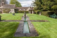 Fountain and formal pool next to the house. Miserden garden, near Stroud, Gloucestershire, UK.
