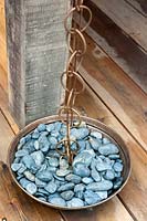 Close up of rain chain with copper bowl of pebbles in the teahouse. 