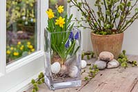 Finished arrangement with Narcissus 'Tete a Tete', Muscari, feathers and eggs.