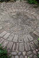 Circular pattern made from brick, pebble mosaic and cobbles
 