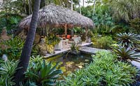The chickee hut and pond in tropical garden. The Jones Residence, Key West, Florida, USA. Garden design by Craig Reynolds.
