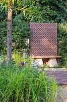 Bench topped with Scottish oak, with staddle stone and brick screen. 'South Oxfordshire Landscape Garden', designed by Rory Andrews, RHS Hampton Flower Show, 2018. 