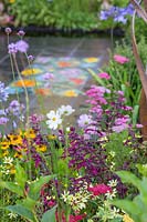Purple Salvia in flower bed in the 'Brilliance in Bloom' garden, with mosaic,
 by Nickie Bonn and Art4Space, set in paving beyond