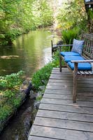View up a creek with a wooden deck viewing terrace on a bank 