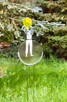 Playing Catch - artwork of fused glass - set in long grass with conifer backdrop
