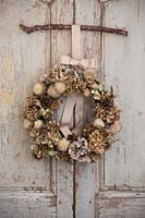 Dried wreath hung up of vintage French doors. Wreath ingredients: Hydrangea, 
Rosa - Rosehip, seedhead, Pine cone and Pheasant feather.
