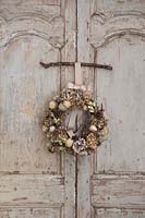 Wreath hung up on vintage French doors. Ingredients include: 
Hydrangea, Rosa - Rosehip, seedhead, Pine cone and Pheasant feather.
