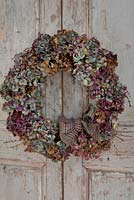Multicoloured dried Hydrangea wreath on vintage French doors