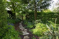 Shady path with stepping stones leading to gate