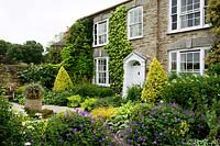 Full shrub and perennial borders at Bosvigo House, Cornwall, UK.