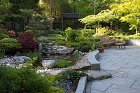 Japanese themed garden with pond, rock garden and paved seating area. 