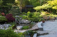 Japanese themed garden with pond, rock garden and paved seating area. 