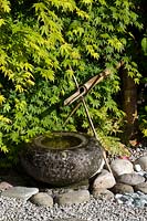 Japanese themed garden with shishi-odoshi in rock garden