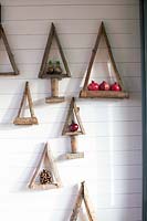Various Christmas tree wall decorations made from wooden branches 