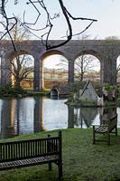 View across lake to viaduct at Kilver Court, Somerset, UK. Designed by Roger Saul of Mulberry.