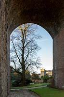 View through viaduct arch to tree and gardens of Kilver Court, Somerset, UK. Designed by Roger Saul of Mulberry. 