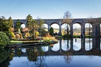 View across lake to viaduct. Kilver Court, Somerset, UK. Designed by Roger Saul of Mulberry.