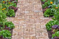 Finished basket weave brick path, edged with vegetables and flowers. 