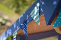 Detail of blue bunting on painted children's playhouse. 