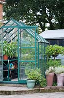 Traditional glass-greenhouse with pots of vegetables. 