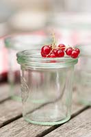 Preserving jar with currants on the top.