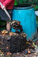 Turning compost back into bin to access the most composted material 