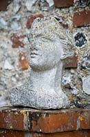 Classic bust - statue of face and head on garden wall 