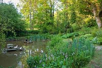Large natural pond with bird house. Lewis Cottage Garden, Devon, UK.