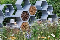 A wall made from honeycomb shapes containing twigs to encourage solitary bees. 
