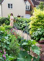 Pauline Fox - Garden owner walking along gravel path with mixed planting