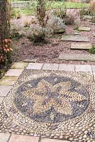 Pebble mosaic in the shape of a flower at Ellicar Gardens, Doncaster, UK. 