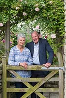 Colin and Erica McGarrigle at the gate of their walled rose garden.