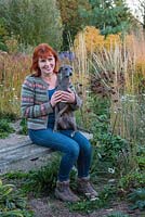Sarah Murch, garden designer, with Luka, an Italian greyhound, in her garden in autumn.