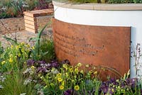 Rusted metal inscription next to a mixed border  -  The Redshift, RHS Malvern Spring Festival 2019