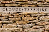 'Gloucestershire' plaque set into the wall identifying the origin of nearby apple trees
