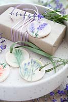 Wrapped present with gift tags made of salt dough and painted pressed flowers 