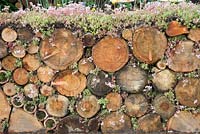 A log wall and insect haven in the Very Hungry Caterpillar Garden, RHS Tatton Park Flower Show, 2019.