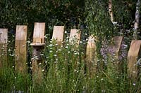 Bird house on wooden garden divider post. Naturalistic planting. The BBC Springwatch Garden.