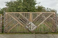 Wooden gate made with branches opening into orchard - Chile