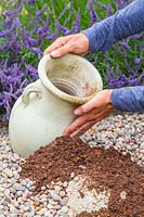 Woman placing urn in gravel