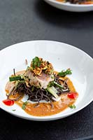 Garden table in Manoj Malde roof garden with food served - seared tuna and noodles.