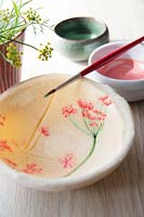 Freshly-painted flower imprints inside a salt dough bowl
