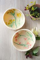 Overview of salt dough bowls decorated with painted flower imprints 